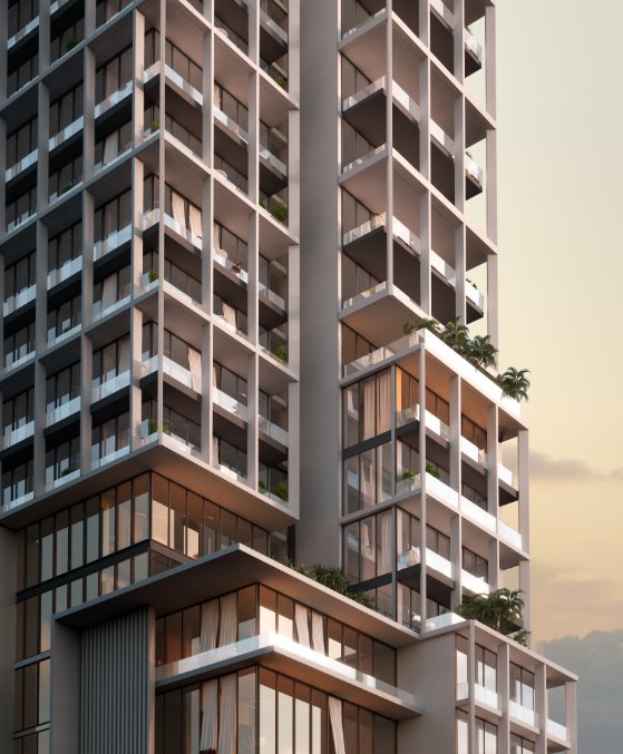 Modern high-rise building at Muheira Maysan with greenery on terraces during sunset.
