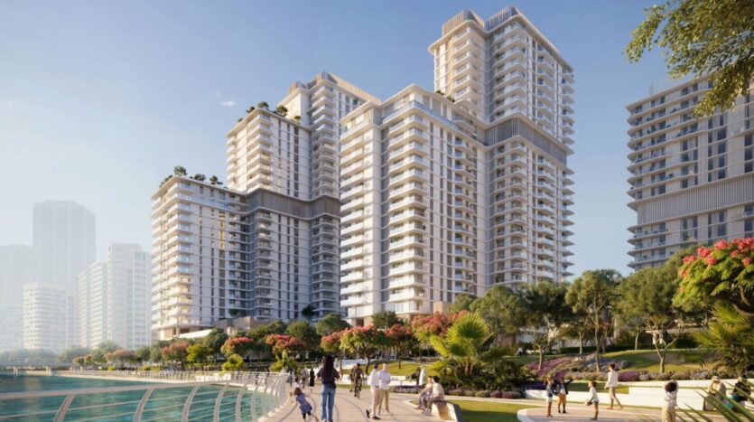 Modern high-rise buildings at Muheira Maysan with a landscaped promenade and residents enjoying the outdoors.