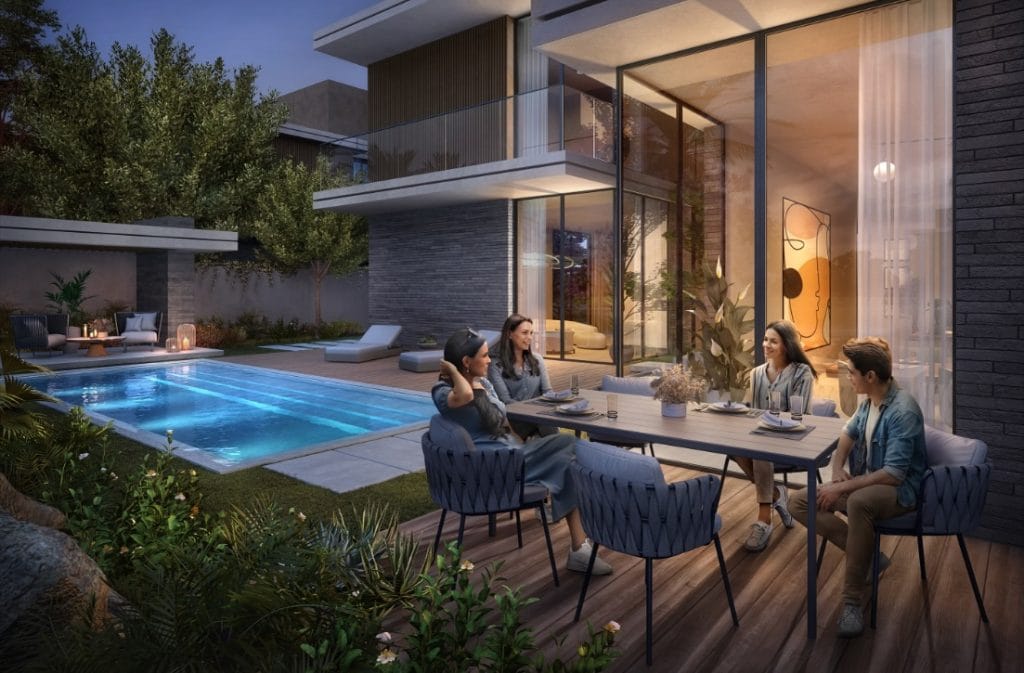 Luxury outdoor dining at The Wilds in Dubai, featuring a modern villa, pool, and family enjoying Cassia Villas.
