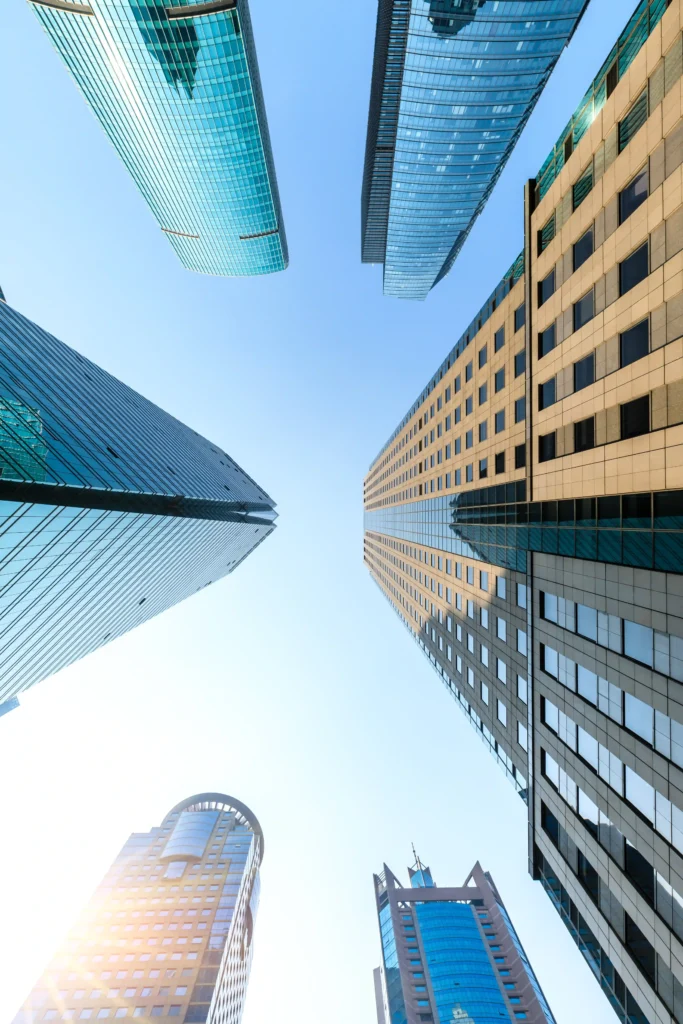 Apartments for sale in Dubai showing Skyscrapers viewed from ground perspective.