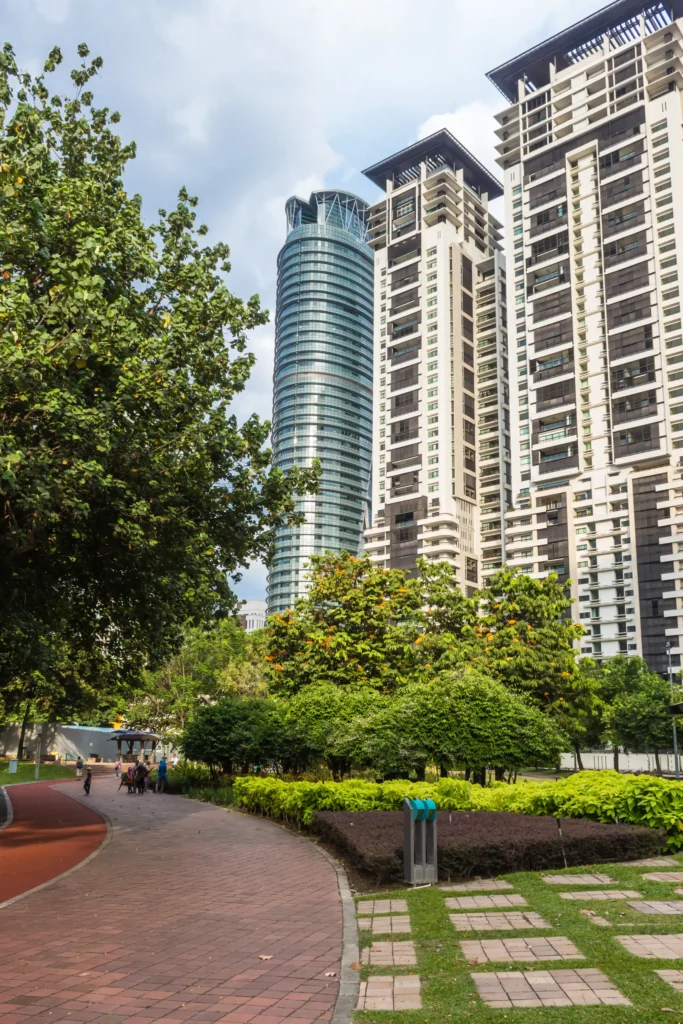 apartments for sale in abu dhabi that has Tall buildings beside a lush garden where