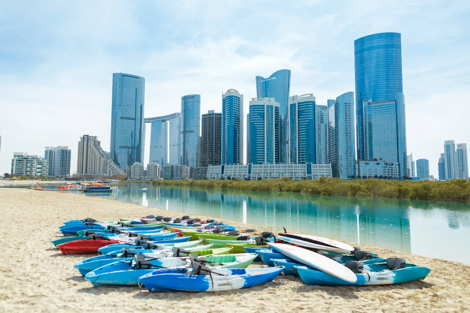 Colorful kayaks on sandy beach part of property for sale in al reem island